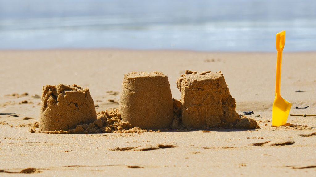a sand castle on a beach with a shovel