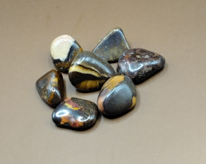 Piedras pulidas de Jaspe Nguni con tonos oscuros y vetas doradas, ideales para meditación, decoración y equilibrio emocional.