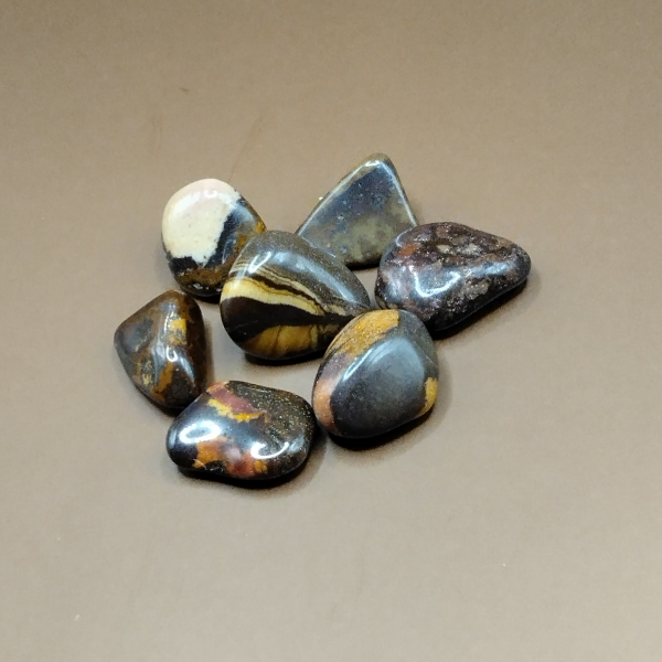 Piedras pulidas de Jaspe Nguni con tonos oscuros y vetas doradas, ideales para meditación, decoración y equilibrio emocional.
