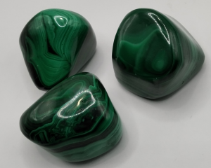 Piedras pulidas de Malaquita con un intenso color verde y vetas naturales, ideales para protección, equilibrio emocional y transformación personal