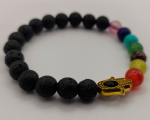 Pulsera de piedra volcánica con cuentas de chakra en colores vivos y un colgante de Hamsa dorado con un ojo central, representando protección y equilibrio espiritual.