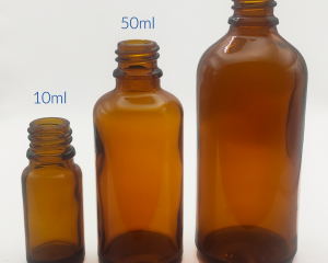 Tres botellas de vidrio ámbar de diferentes tamaños, 10 ml, 50 ml y 100 ml, alineadas, mostrando la versatilidad de opciones para almacenar y preservar productos aromáticos.