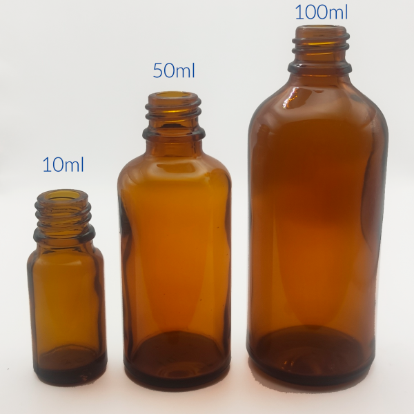 Tres botellas de vidrio ámbar de diferentes tamaños, 10 ml, 50 ml y 100 ml, alineadas, mostrando la versatilidad de opciones para almacenar y preservar productos aromáticos.